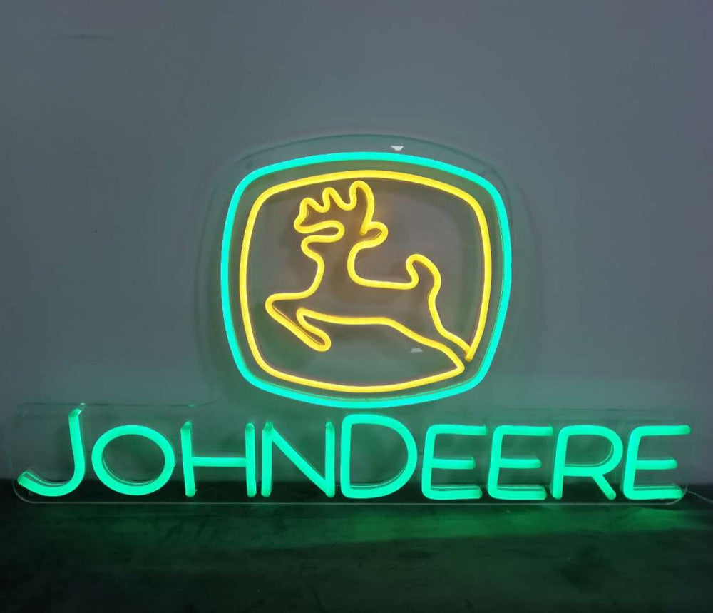 Afgewerkt neonbord met John Deere-logo, gloeiend in groen en geel